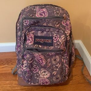 JanSport Cool Student floral backpack with synthetic leather base and trim.